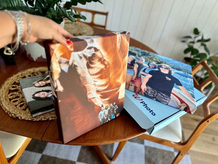 woman holding up a walgreens canvas prints on a table