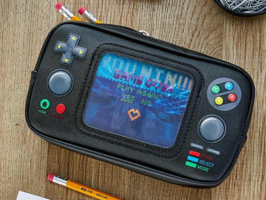 handheld video game shaped pencil case on a desk with pencils