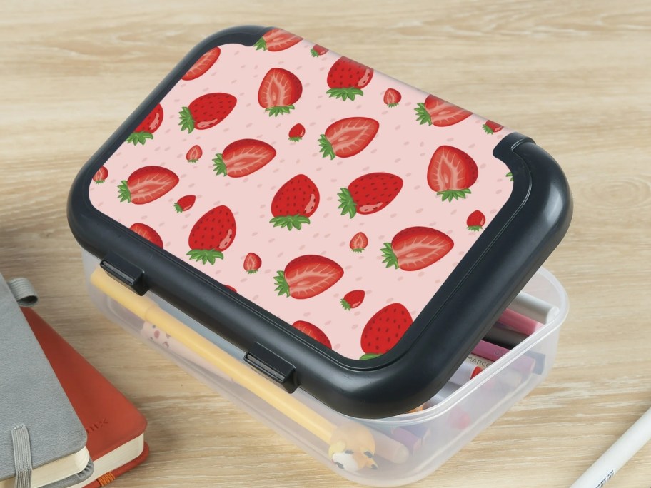 pencil box with clear base and lid with black and pink and strawberries