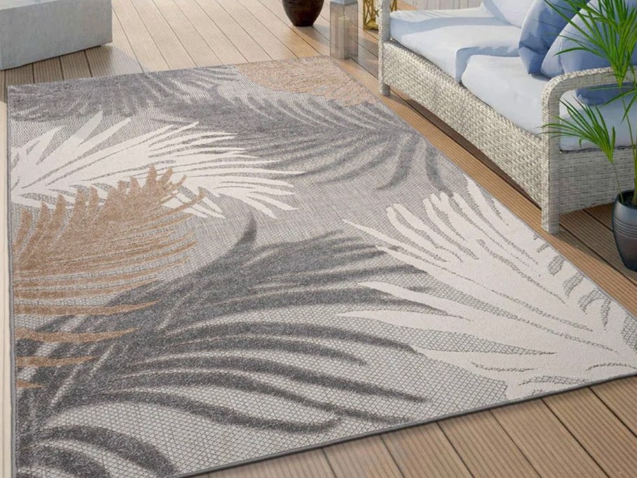 gray and beige floral area rug on patio 