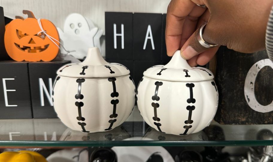 white ceramic pumpkin jars on a store shelf