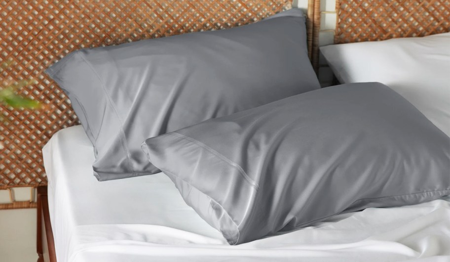 two grey grey satin pillowcases on bed