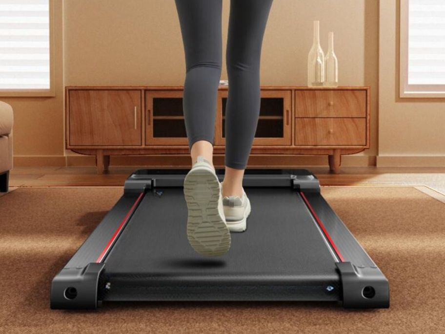 woman walking on CURSOR FITNESS Under Desk Treadmill with Full-Screen Display in living room