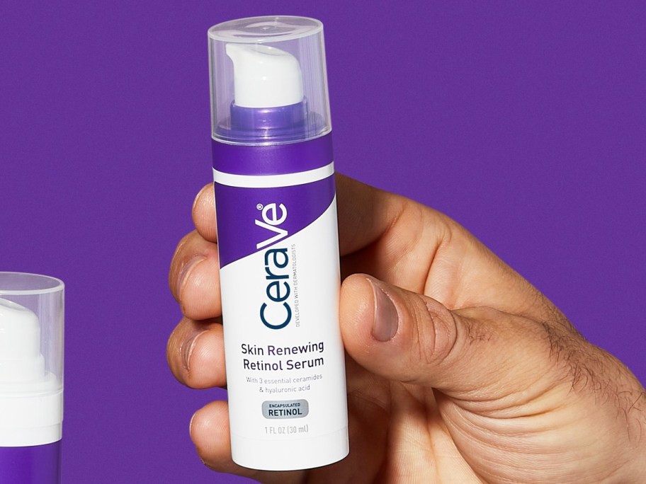 hand holding a white and purple tube of CeraVe Skin Renewing Retinol Serum