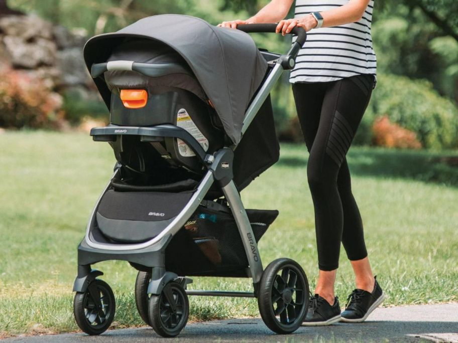 Mom outside pushing a Chicco Bravo Trio Travel System Stroller w/ KeyFit 30 Infant Car Seat