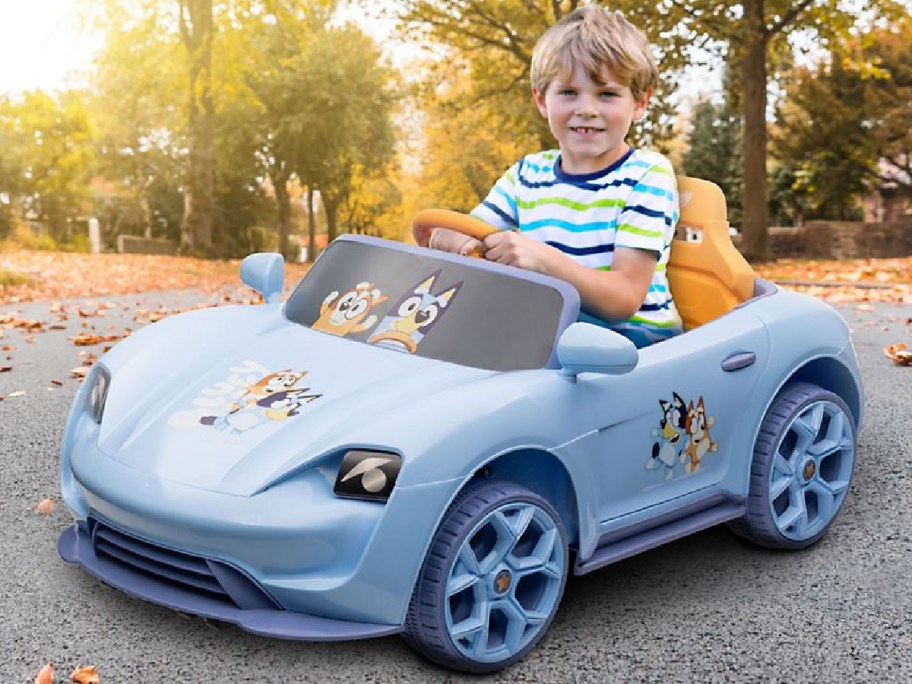 Child in a bluey convertible ride on toy