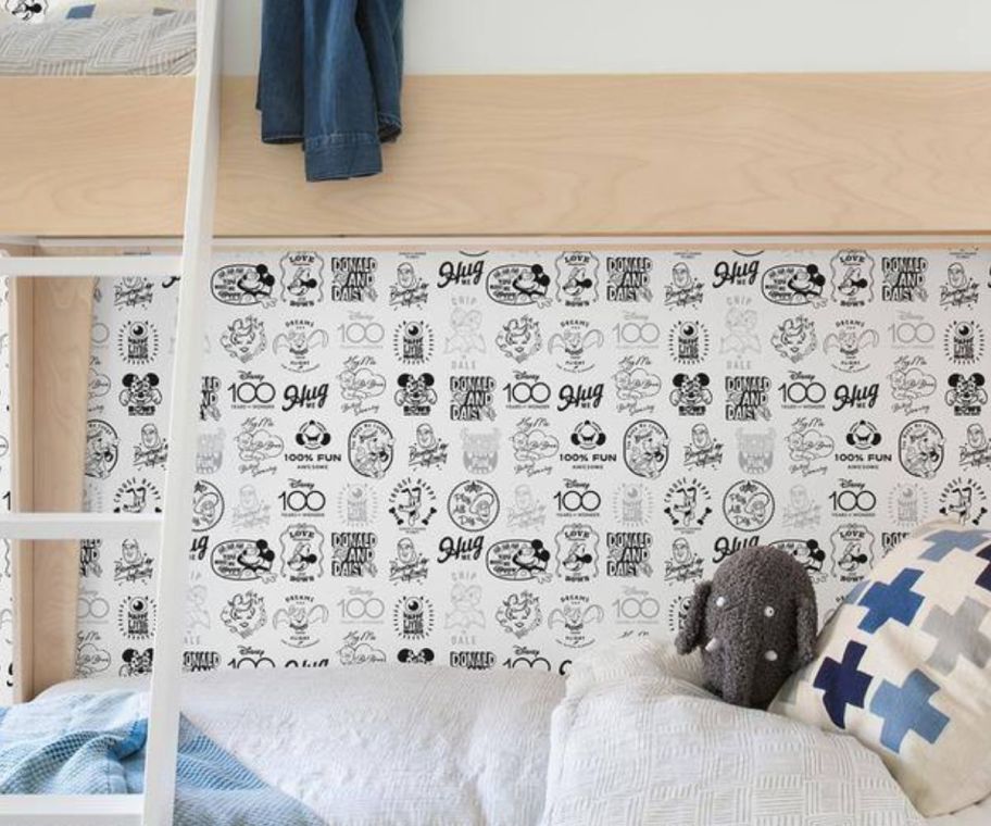 a child's room wallpapered with Disney 100th wallpaper