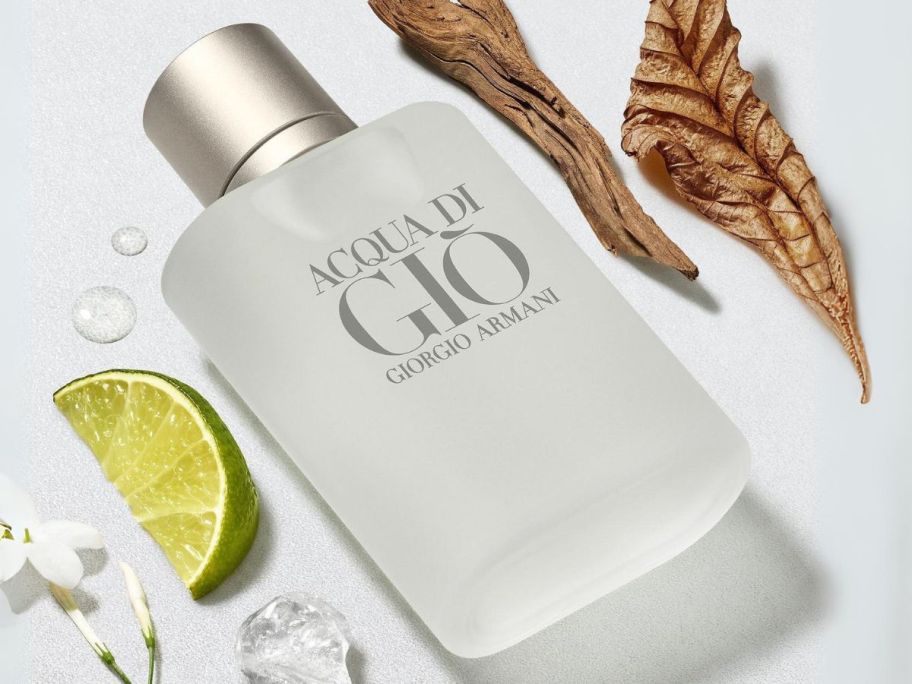 Giorgio Armani Acqua Di Gio for Men, Eau De Toilette Spray 3.4oz laying down next to leaves and a lime slice