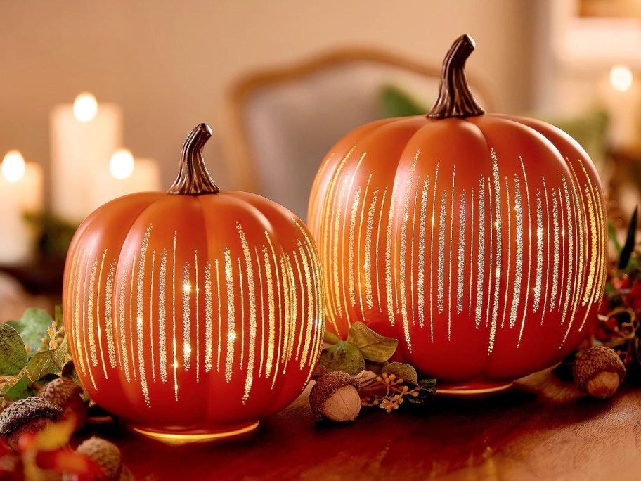 two orange Illuminated Starry Night Glass Pumpkins