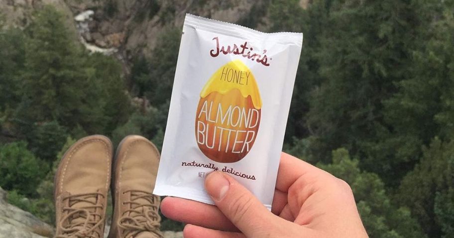 hand holding Justin's Honey Peanut Butter Squeeze Packs 1.15oz