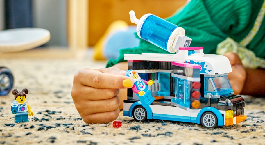 child on floor playing with LEGO City Penguin Slushy Van Building Toy