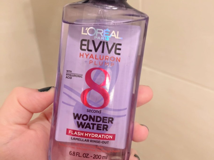 bottle of L'Oreal Paris Elvive Wonder Water in hand