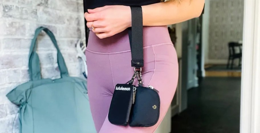 woman holding black wristlet on arm