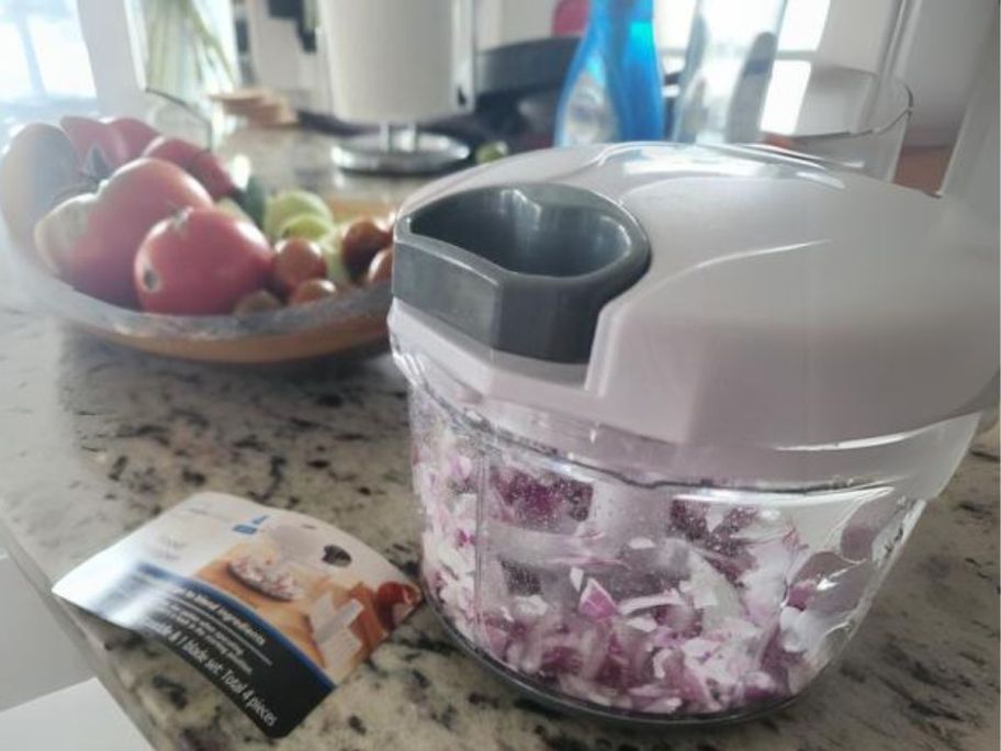 Mainstays 1-Quart Quick Pull Chopper on counter with onions in it and vegetables next to it