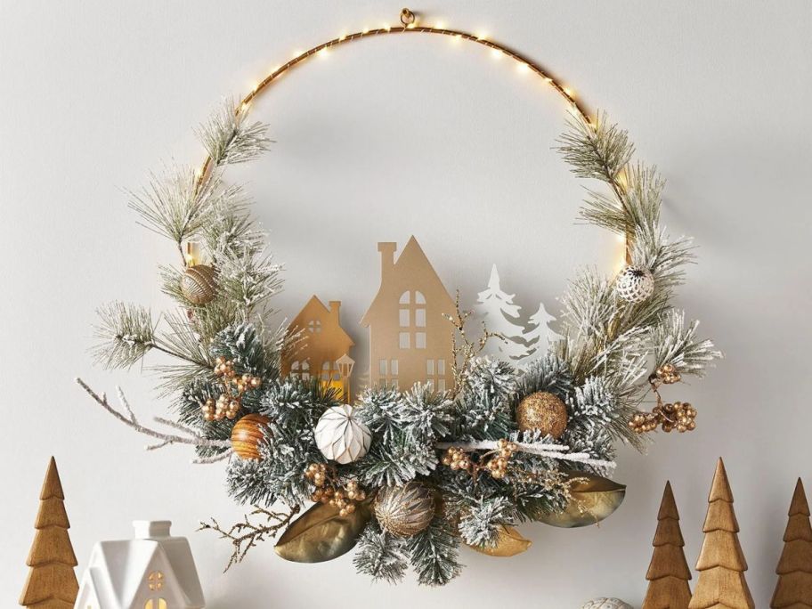 A gold colored wreath with an outline of a house on a wall