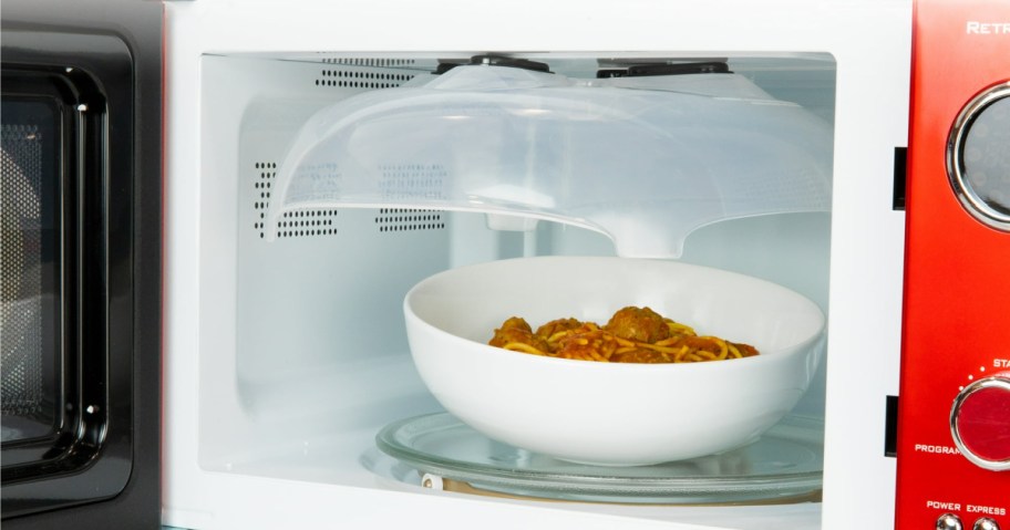 Microwave Splatter Cover in a microwave over a bowl of spaghetti