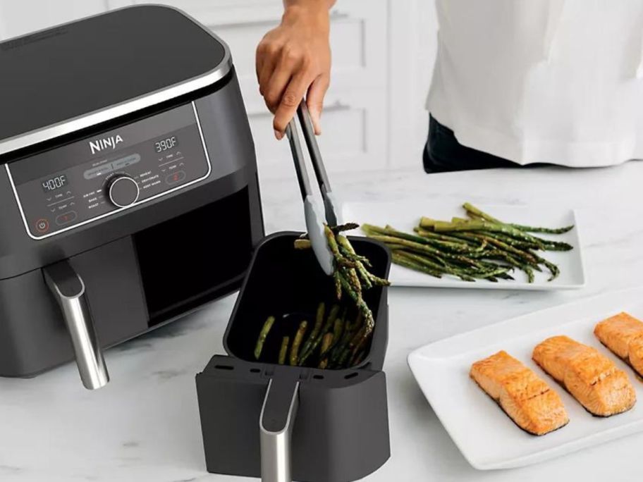 woman using Ninja Foodi 6-in-1 8-Quart 2-Basket Air Fryer w/ DualZone Technology in kitchen