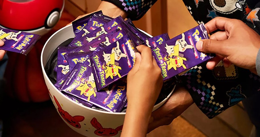 hands grabbing halloween pokemon packs from candy bowl