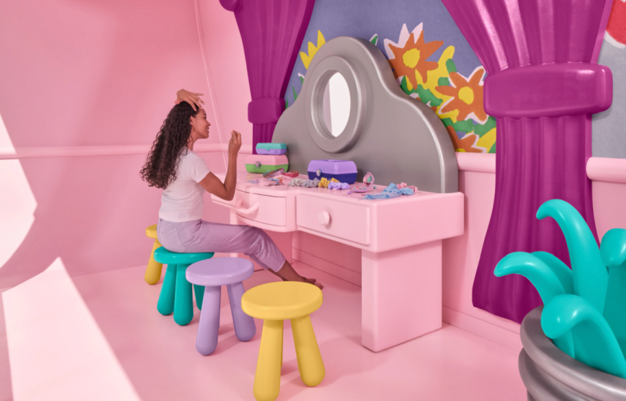 woman sitting at a vanity table in the Polly pocket airbnb