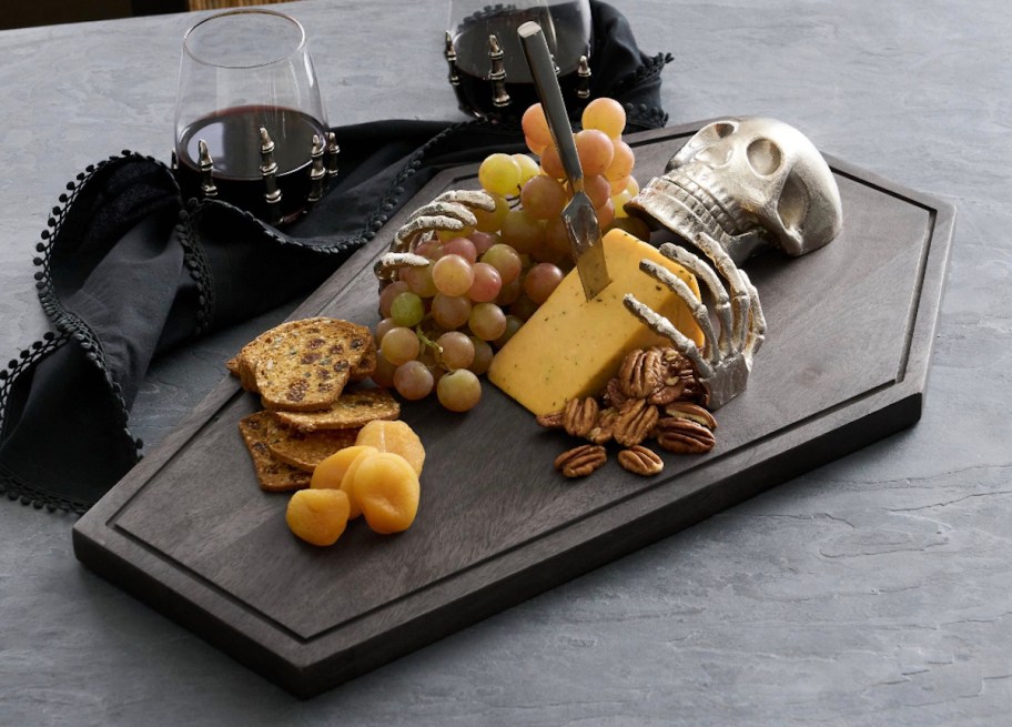 skeleton cheeseboard with charcuterie foods and stemless red wine glasses