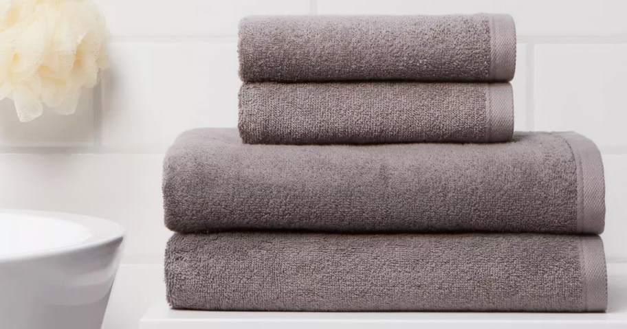 stack of grey bath and hand towels on bathroom counter