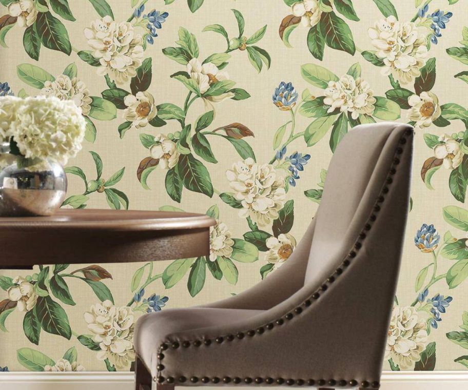 a chair in front of a wall covered with floral print wallpaper