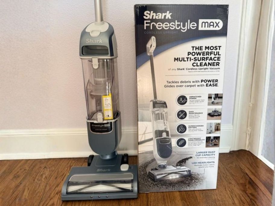 Shark FreeStyle Max Cordless Upright Vacuum next to box against wall