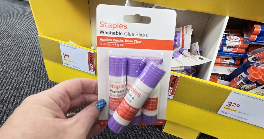 hand holding up a pack of Staples Washable Glue Sticks