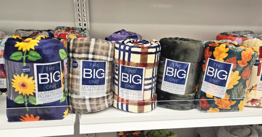 The Big One Oversized Supersoft Plush Throw Blankets in various prints on store shelf