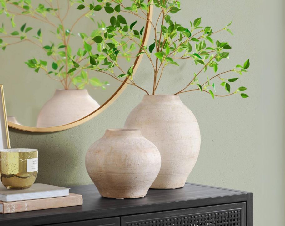 large and small rustic vases on a console table