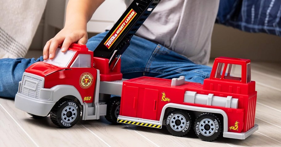 boy playing with a red tonka fire truck