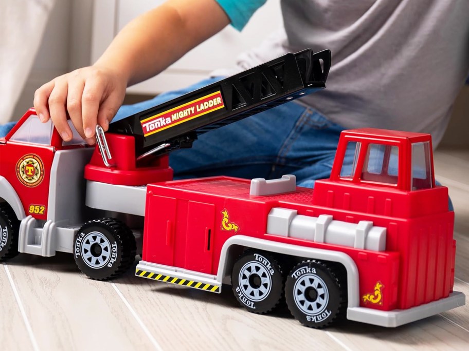 boy playing with a red tonka fire truck