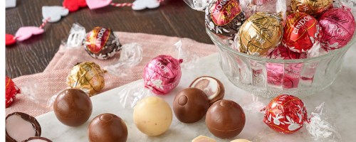 Valentine's day truffles inside of a bowl and displayed ont he side