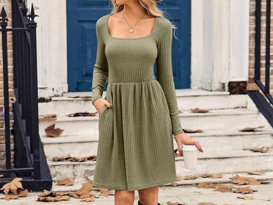 Woman wearing a sweater dress standing in front of stairs