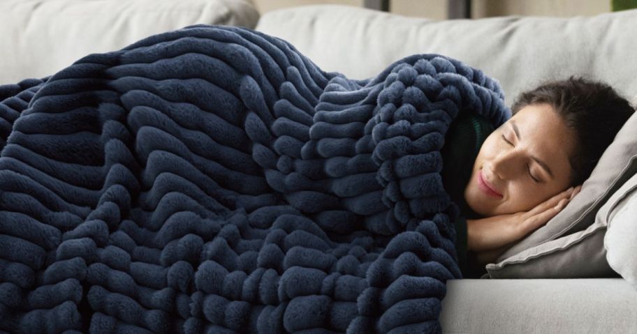 woman laying on couch with blue blanket on her