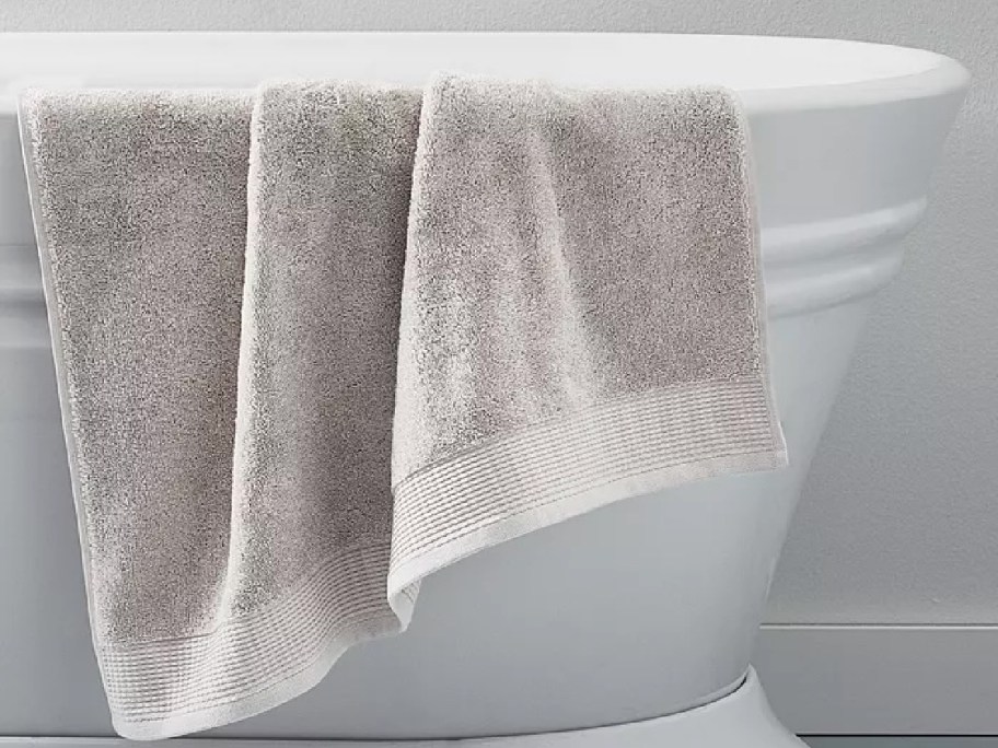 cream bath towel draped over bathtub