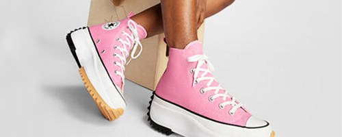 person wearing pink high top converse shoes