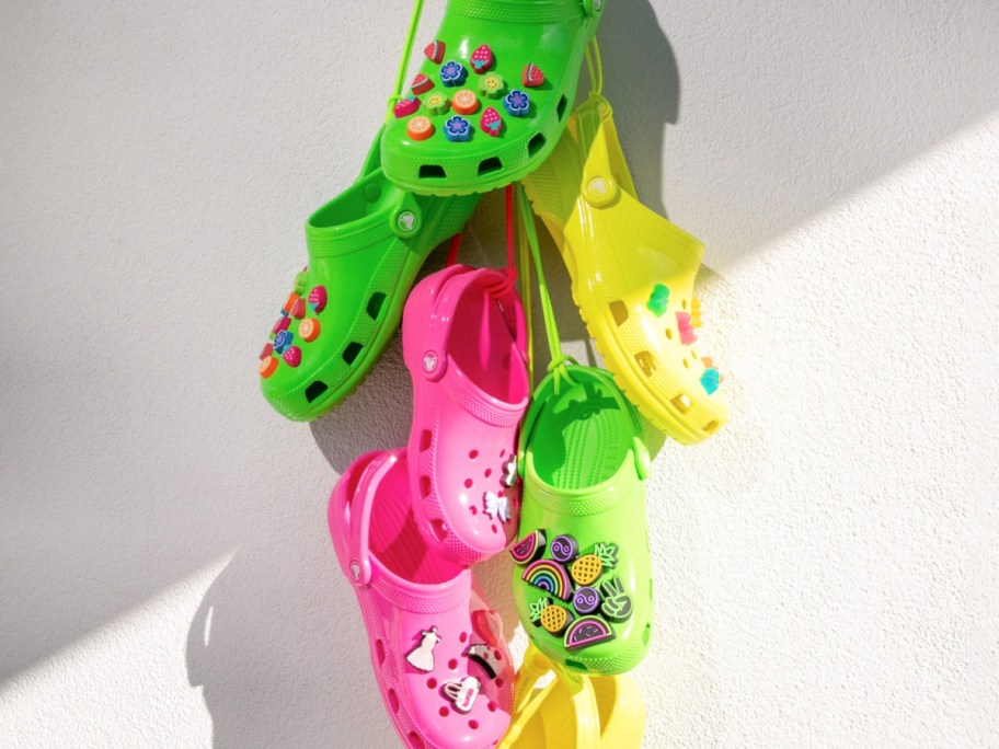 green, pink, and yellow crocs and assorted colorful jibbitz charms