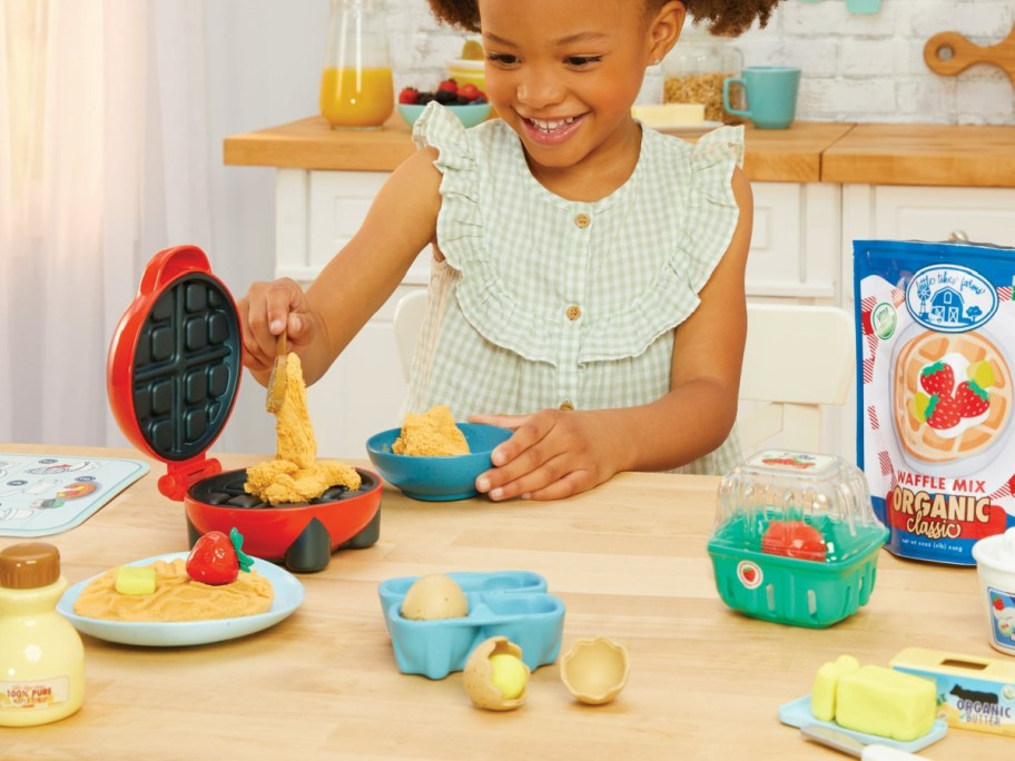 girl using play waffle maker in her kitchen