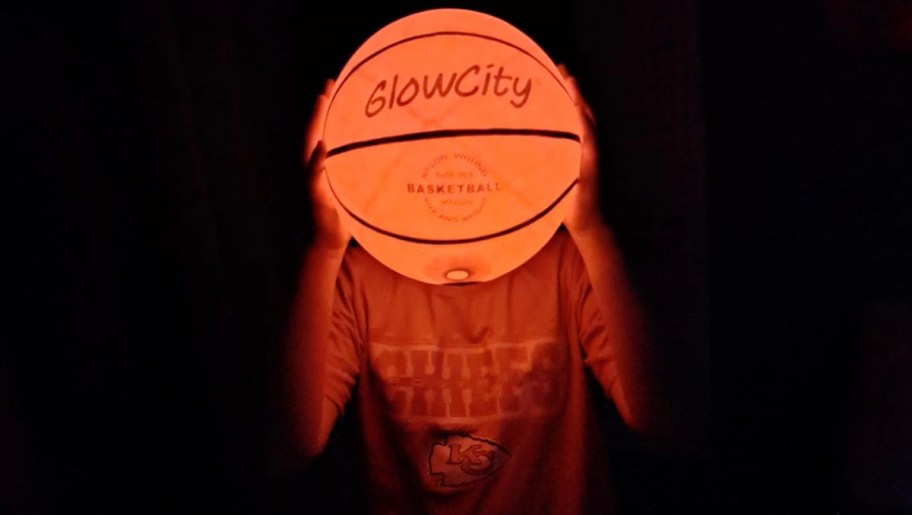 kid holding glow in the dark basketball