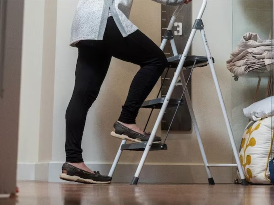 woman climbing on a step stool