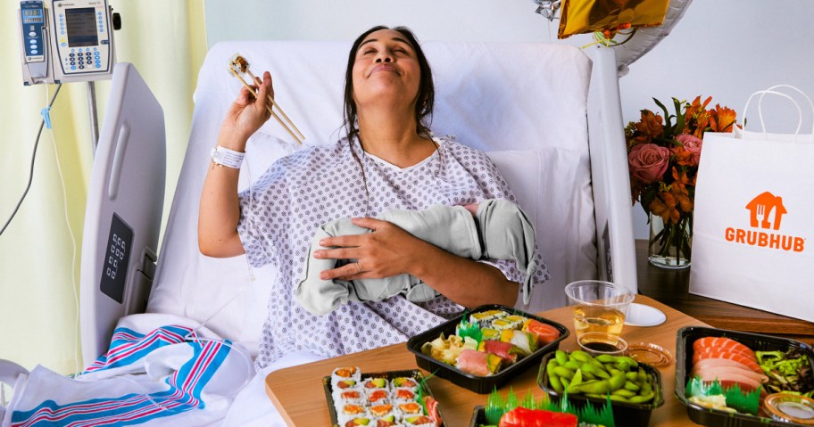 woman in a hospital bed holding a baby surrounded by food