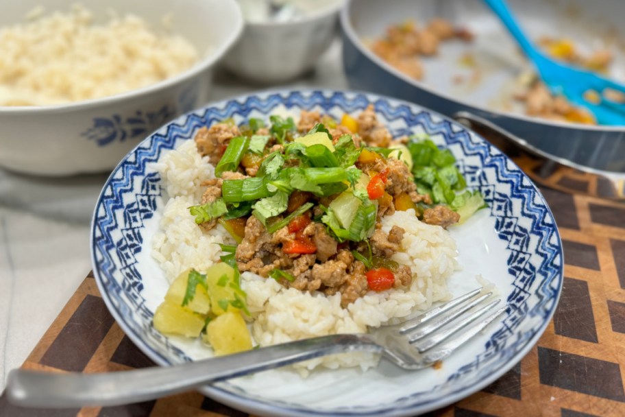 rice and meat in bowl on cutting board