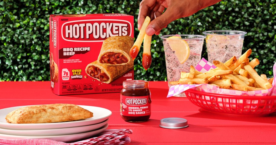 hand dipping fries into a jar of hot pockets bbq sauce