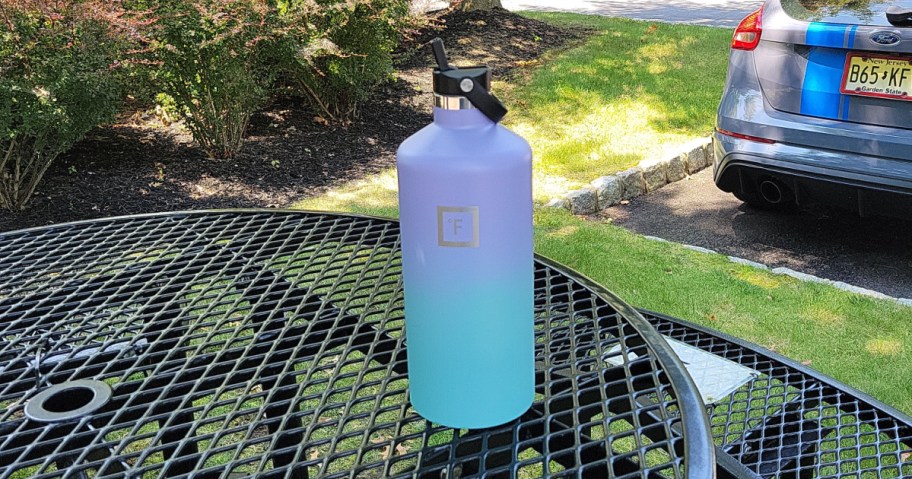 blue and purple iron flask water bottle on a patio table