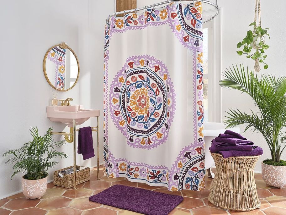a decorative mosaic print shower curtain hanging in a bathroom