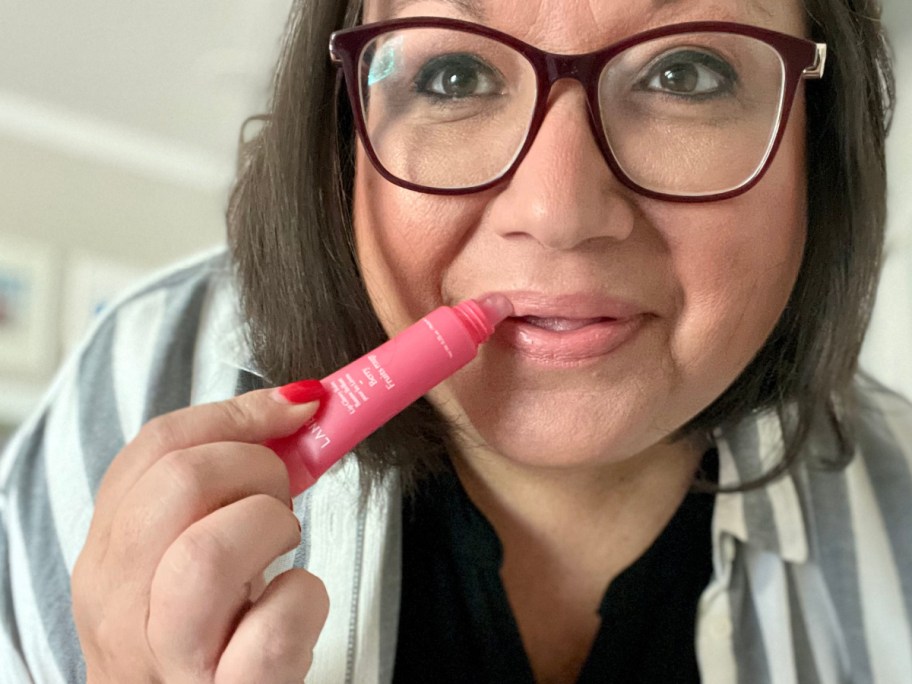 ina applying glowy lip balm