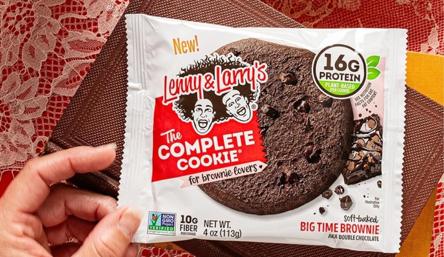 a hand holding a packaged lenny and larry cookie