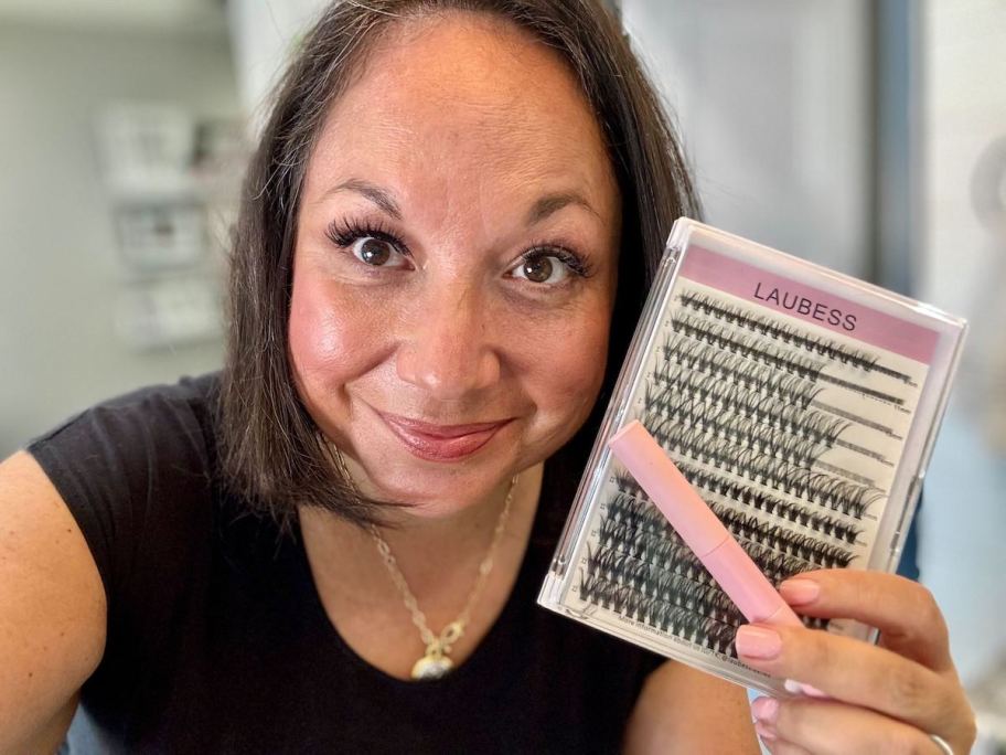 woman holding lash extensions pack in bathroom