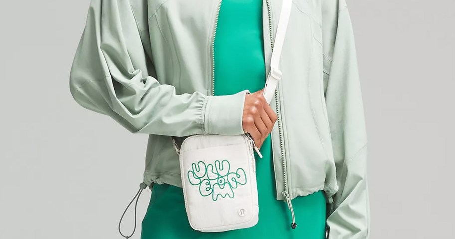 woman in a green outfit with a white and green crossbody bag